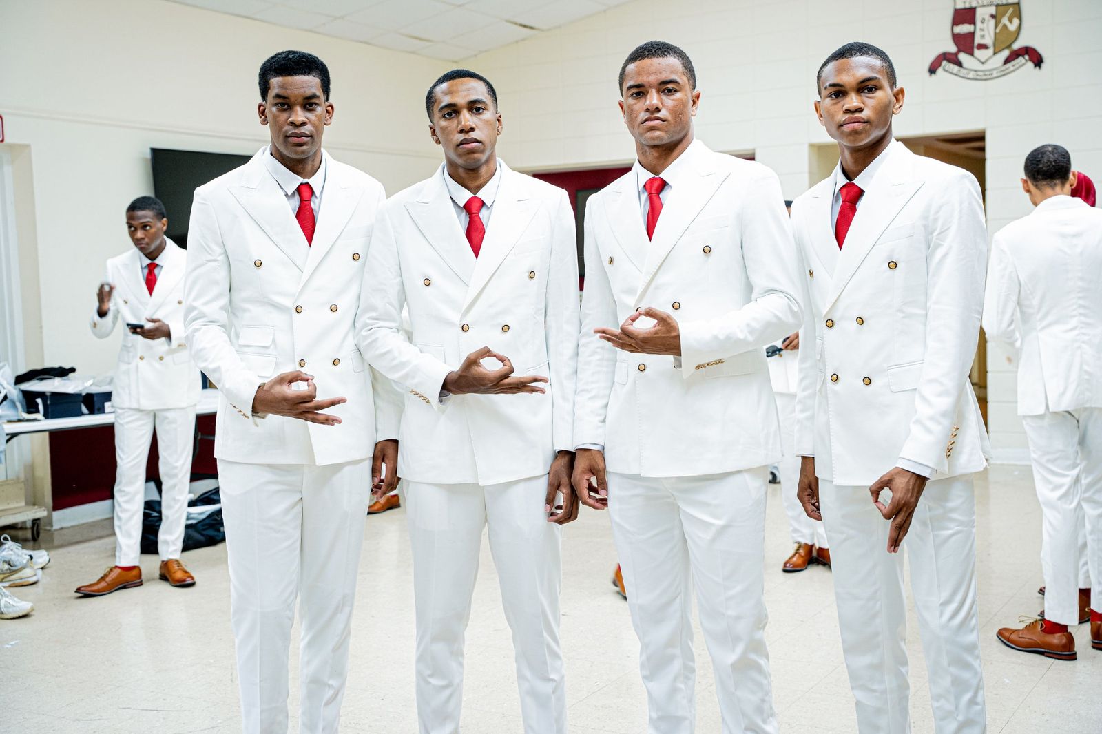Four brothers in white double-breasted suits and crimson ties